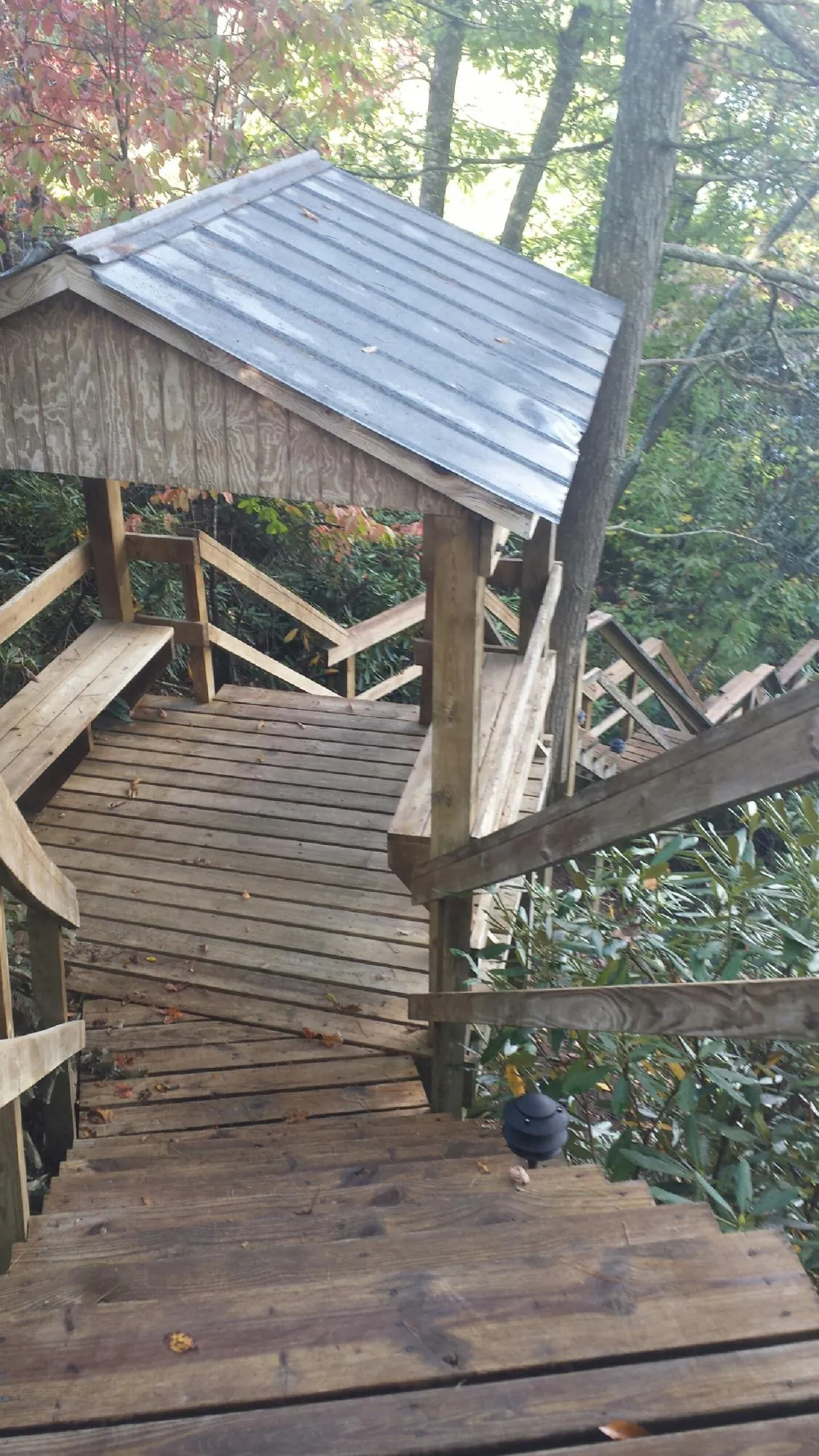 Metal roofed shelter over wooden steps on a wooded walkway — Skylight Repair & Installation work by our crew in Canyon