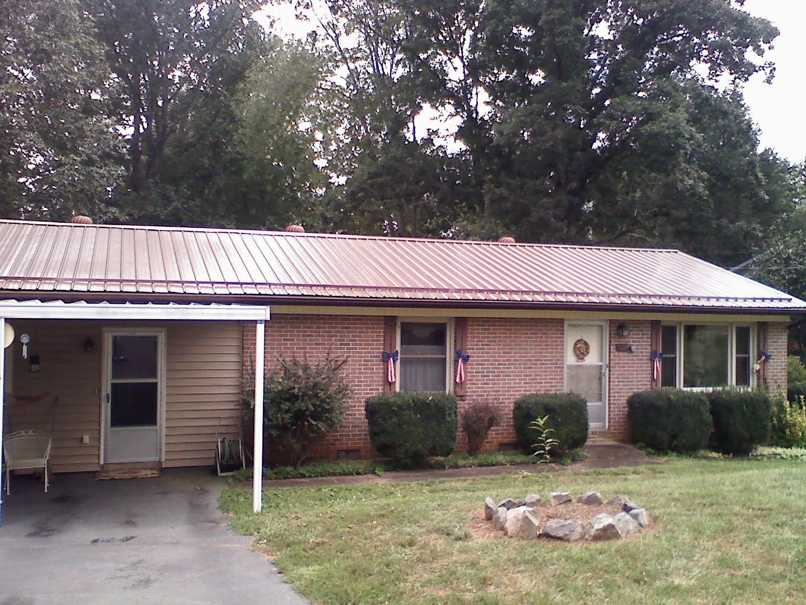 Bronze metal roof and carport on a brick ranch home — Roof Repair work by our crew in Canyon