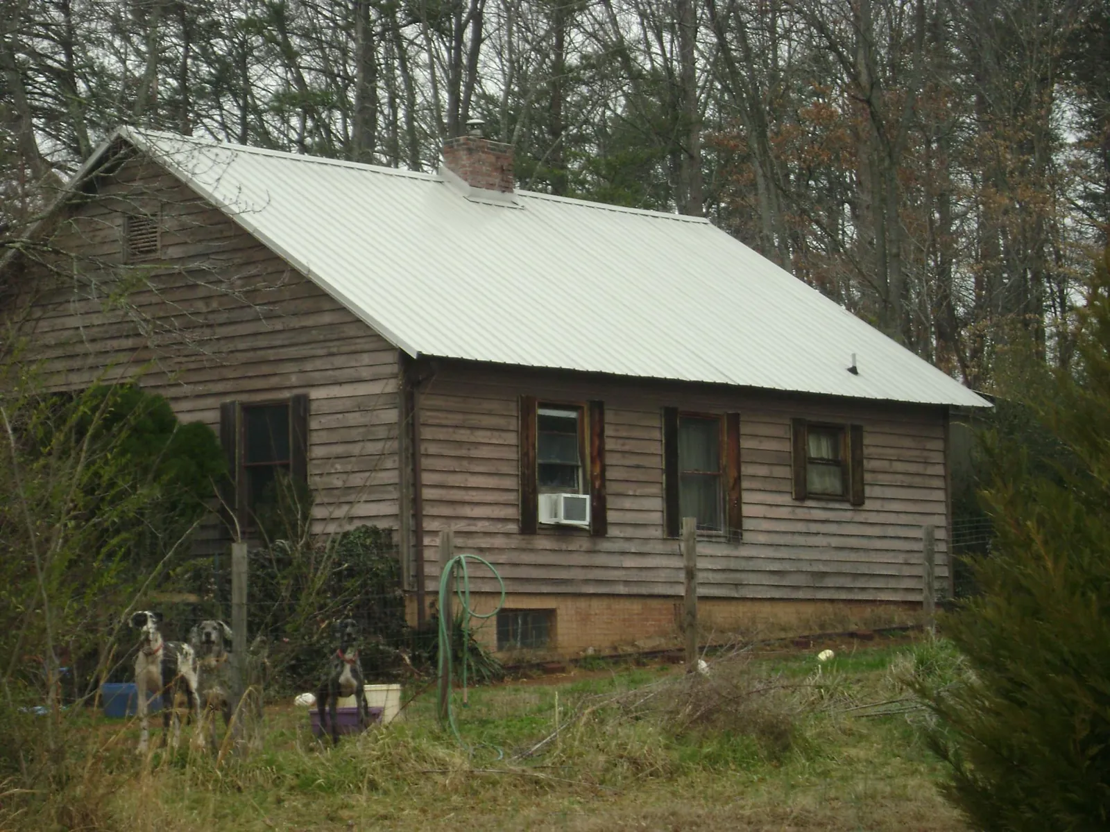 White metal roof on an old wood sided farmhouse, from a Metal Roof Installation job in Canyon